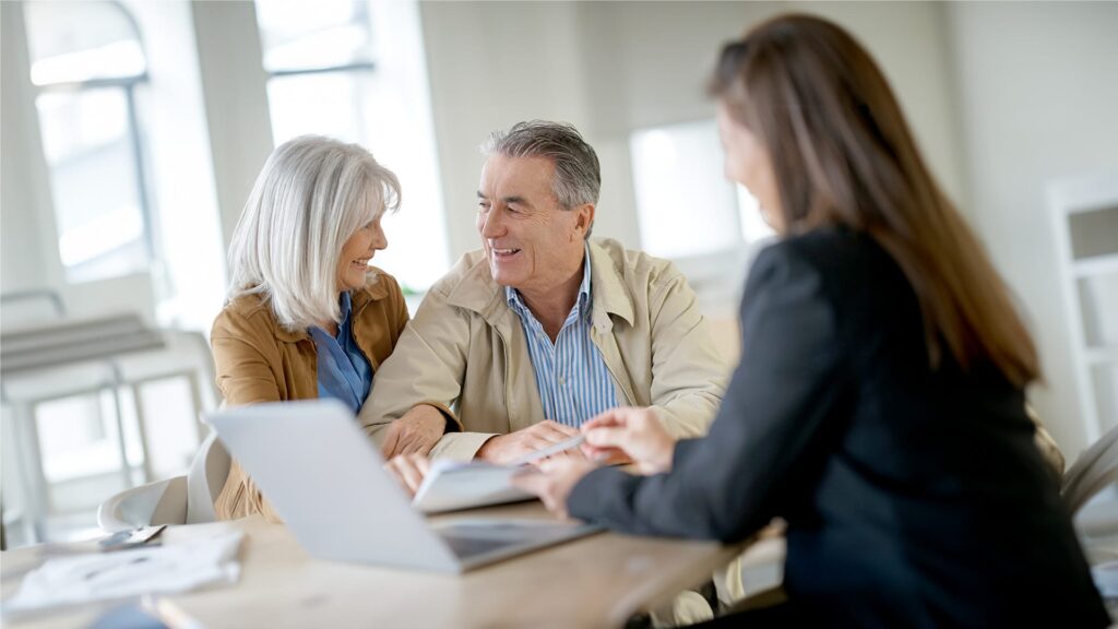 An older couple happy with their NCF Advisor going over documents.