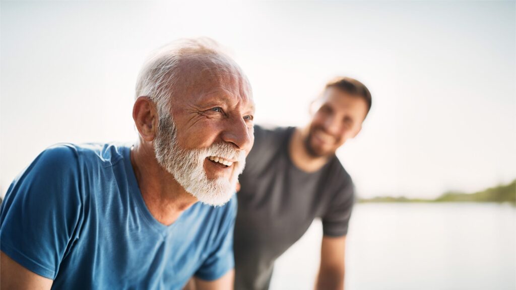 An healthy smiling elderly philanthropist with his son thinking about giving to future generations