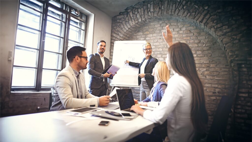 A team in a boardroom having a strategy session with a flipboard