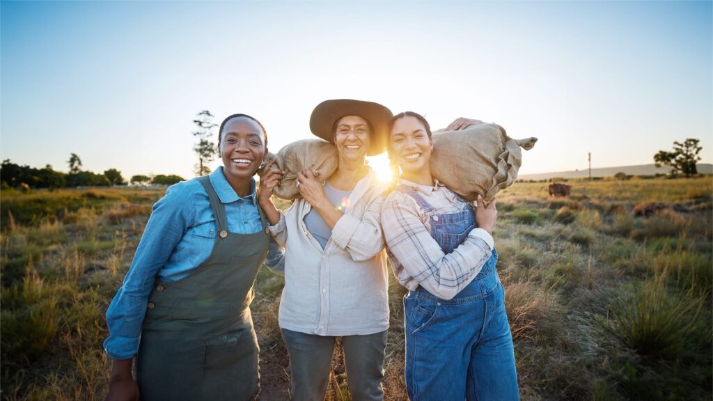 A group of smiling diverse woman farmers in a field.